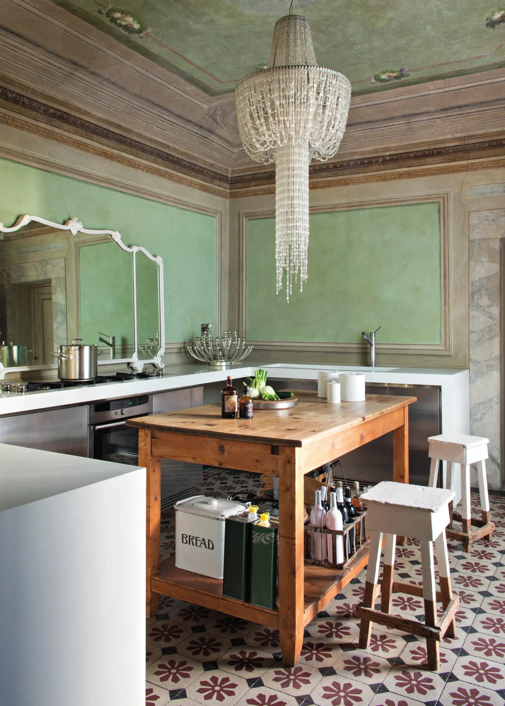 Classico quotidiano: il pavimento decorato dialoga con il lampadario di design e la cucina in acciaio - epoche lontane si incontrano in un equilibrio sorprendente.